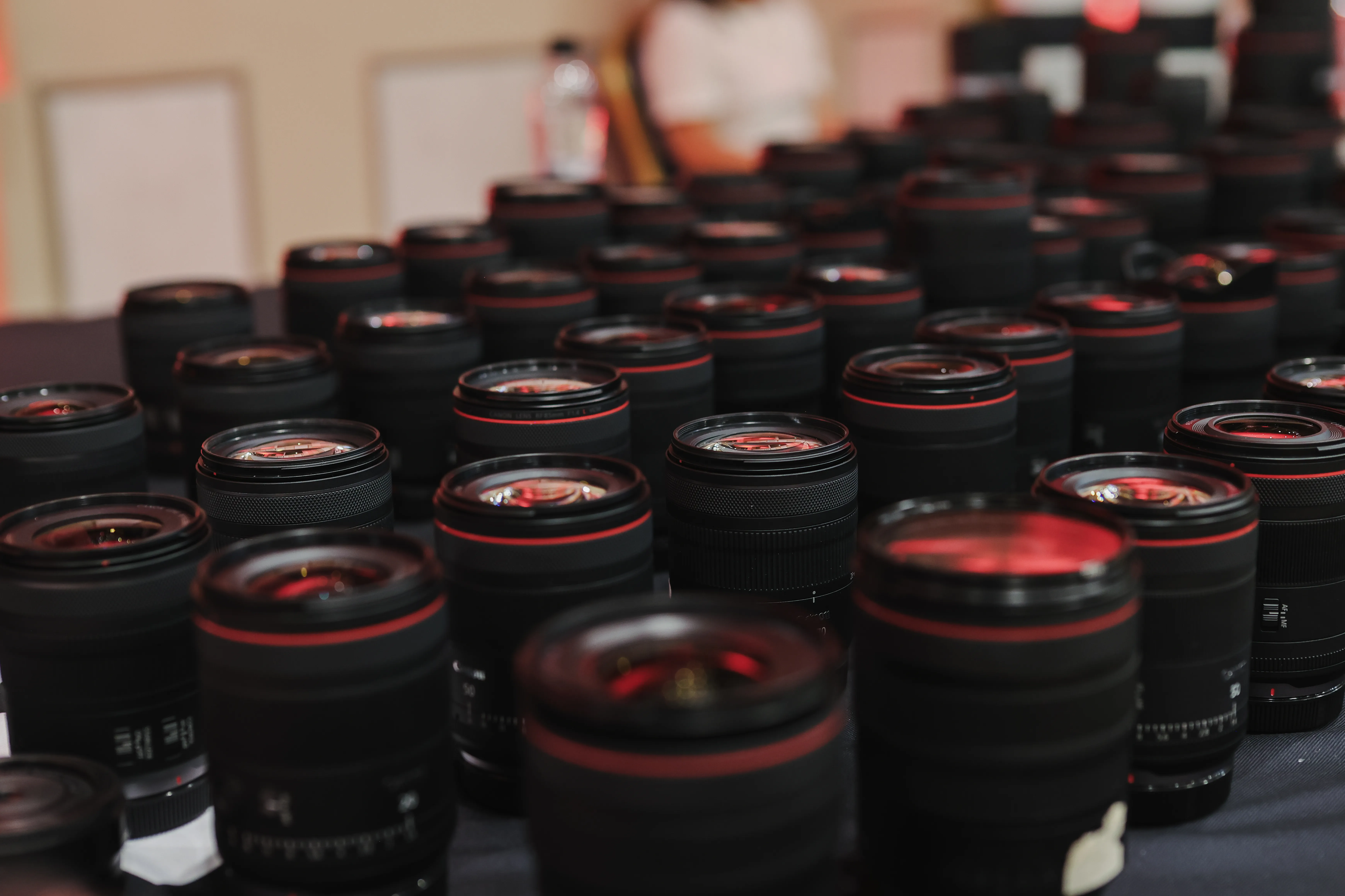 Rows of Canon RF lenses laid out on a table