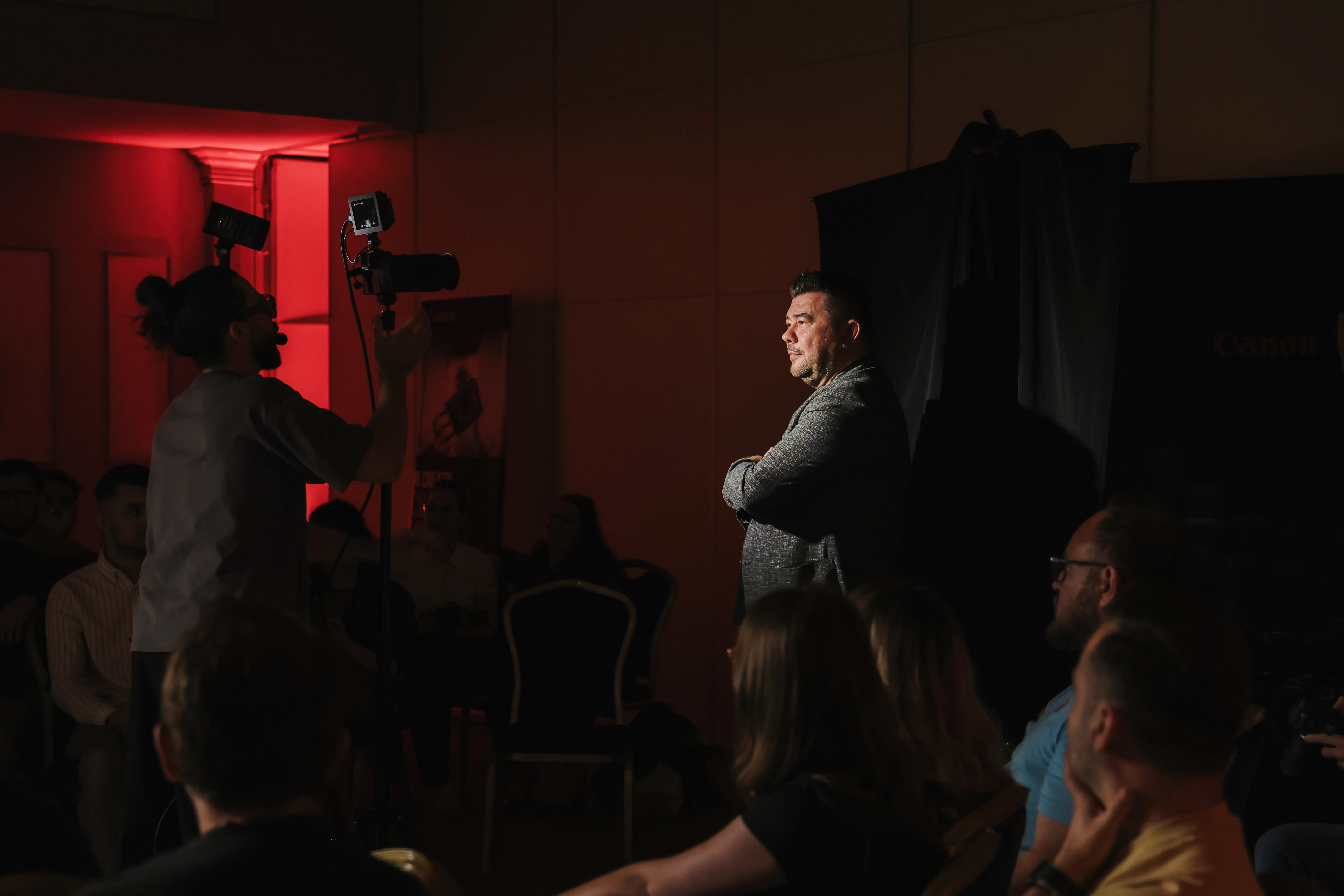 A man watching the demonstration, lit in dramatic red stage light