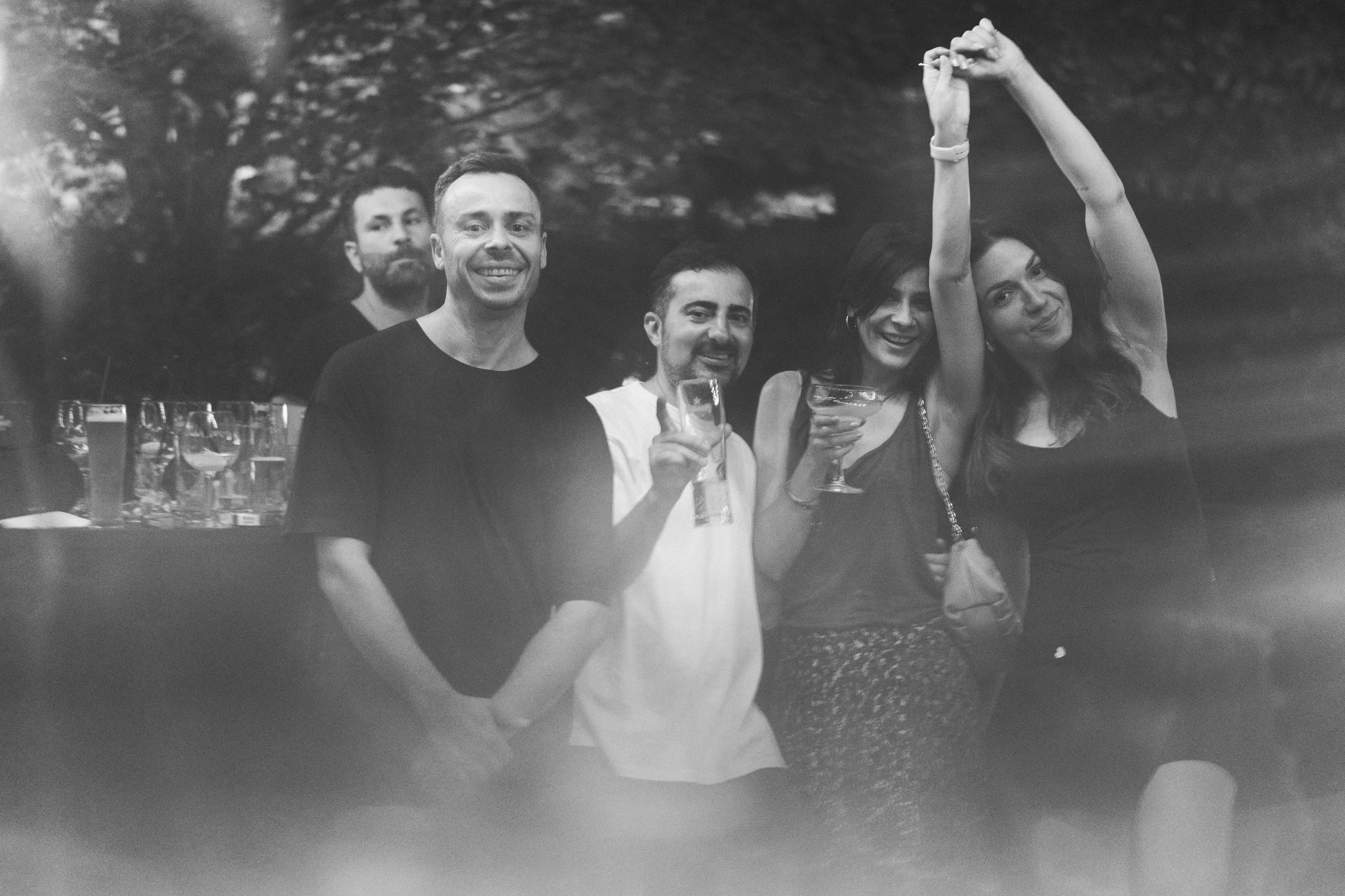 A group of friends caught mid-celebration, black and white