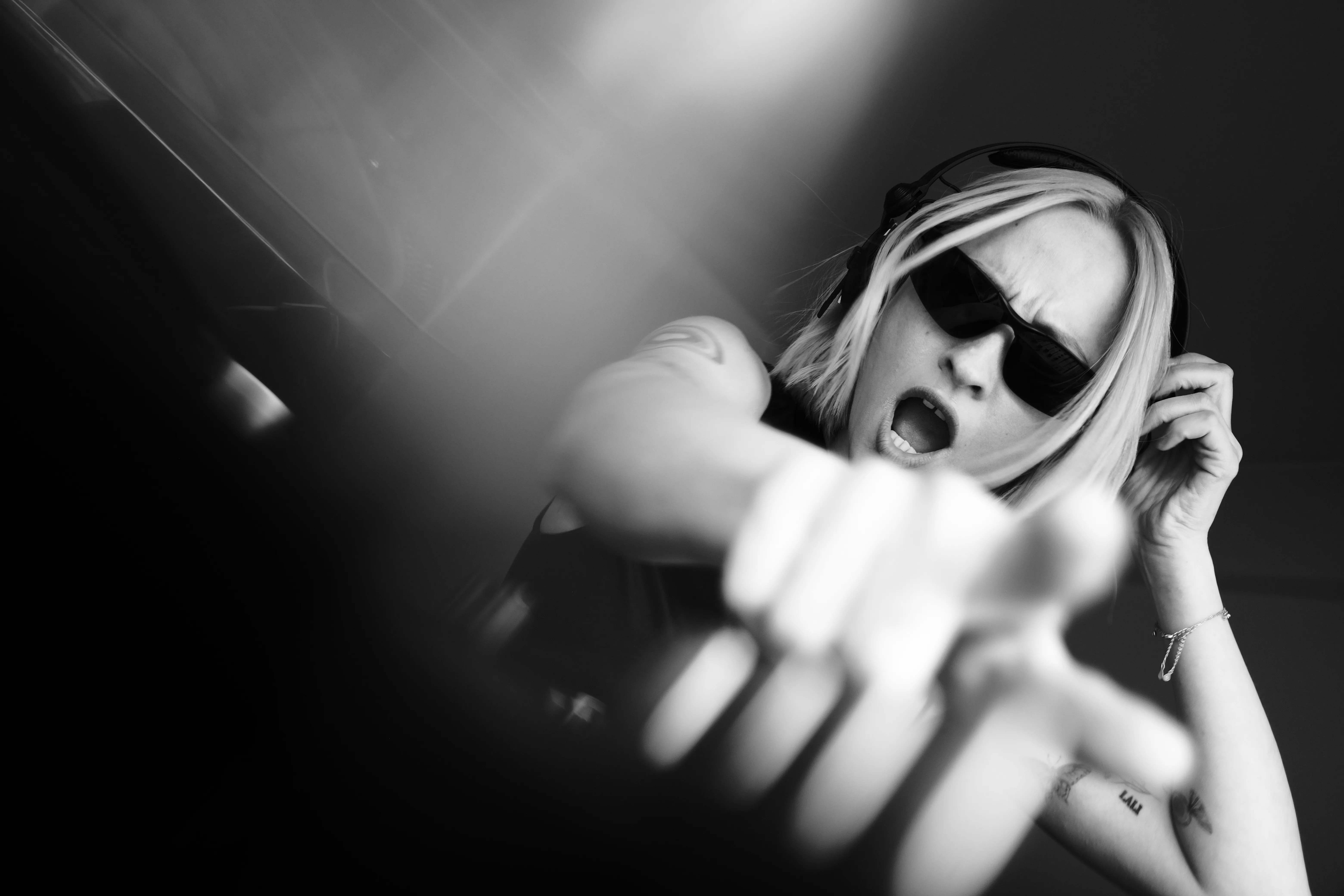 A woman mid-laugh, hand blurred with motion, black and white