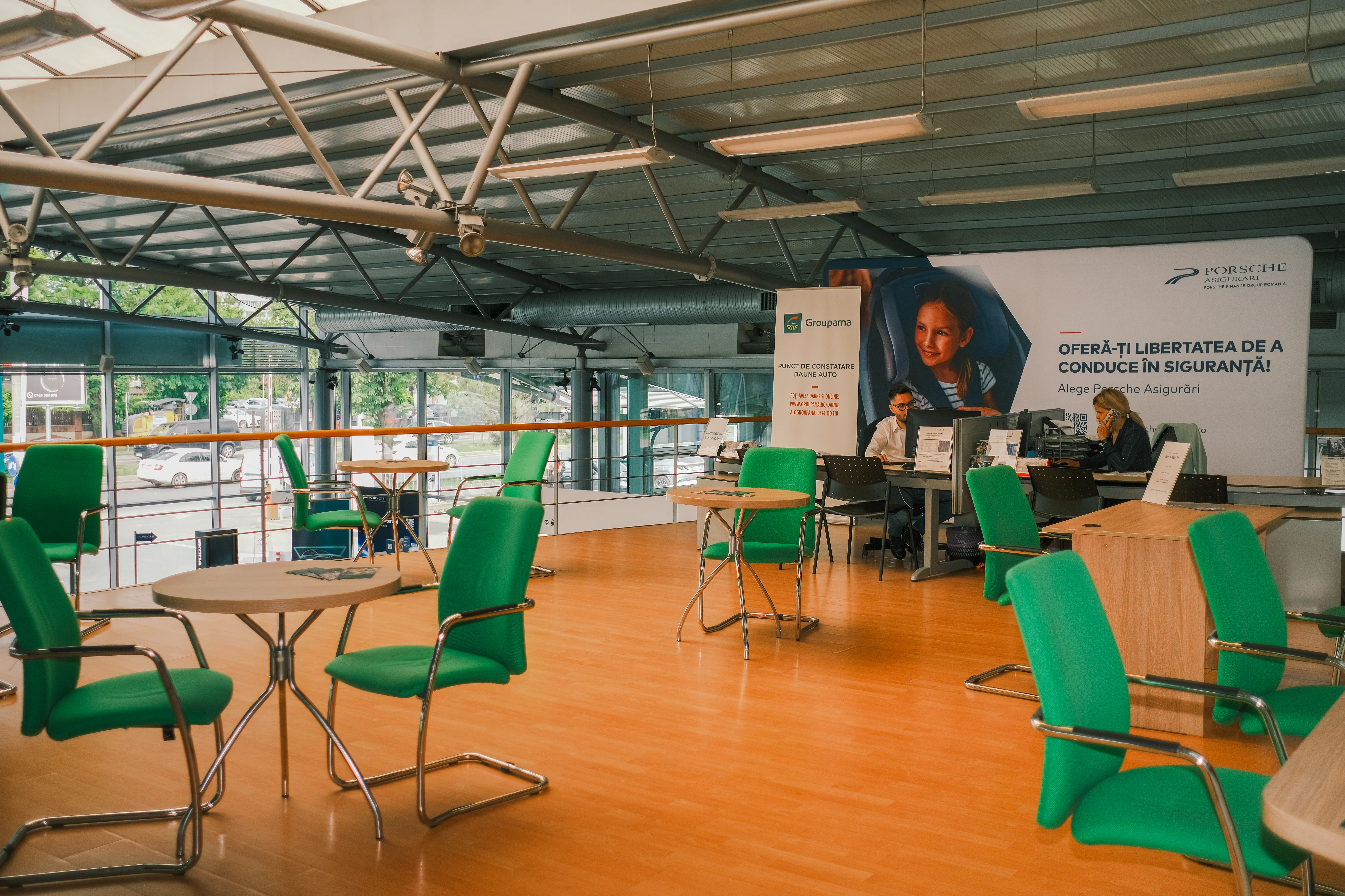 An empty client waiting area, green chairs around a low table, morning light through the windows