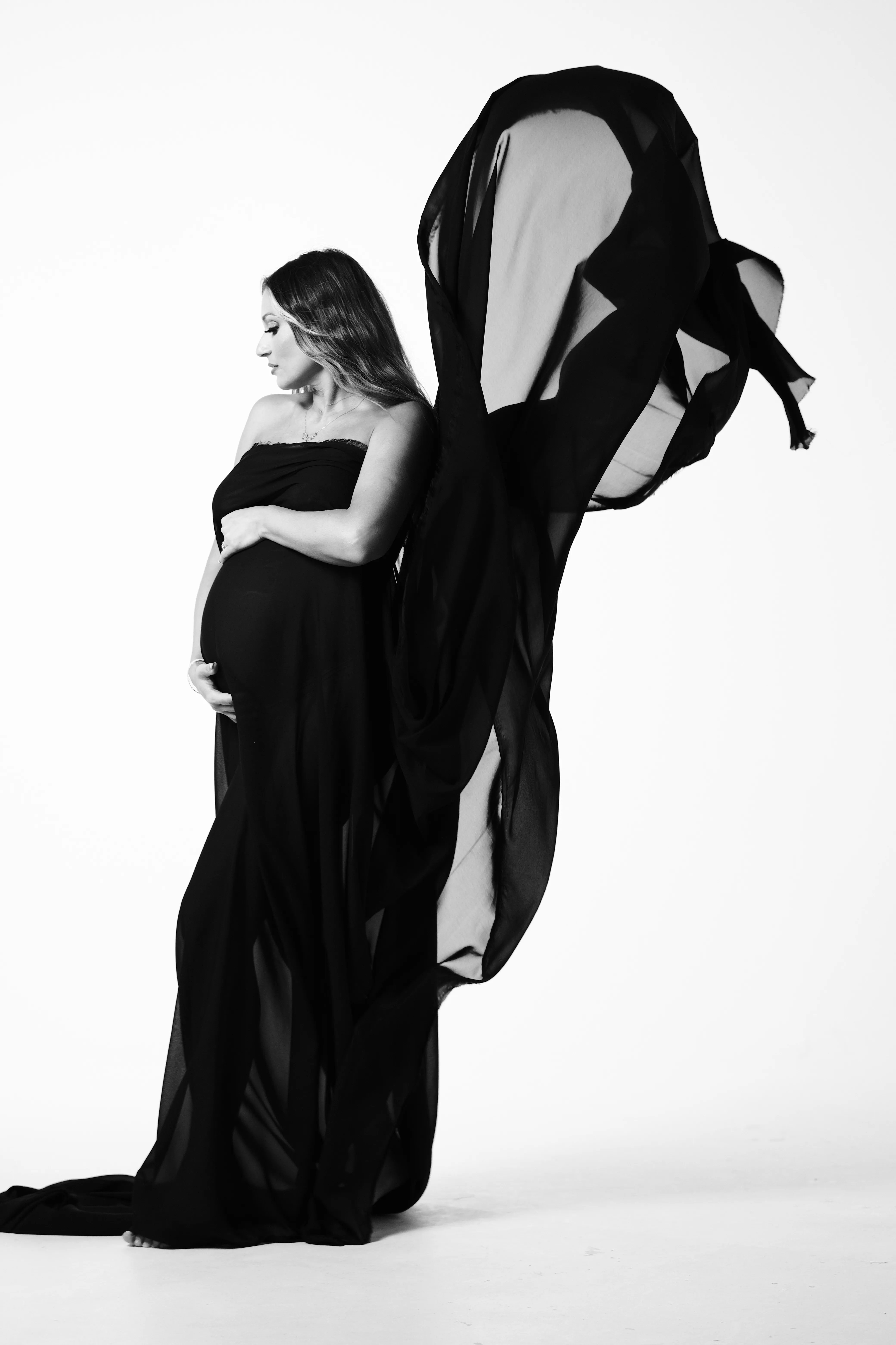 Silhouette in flowing black fabric against a plain backdrop