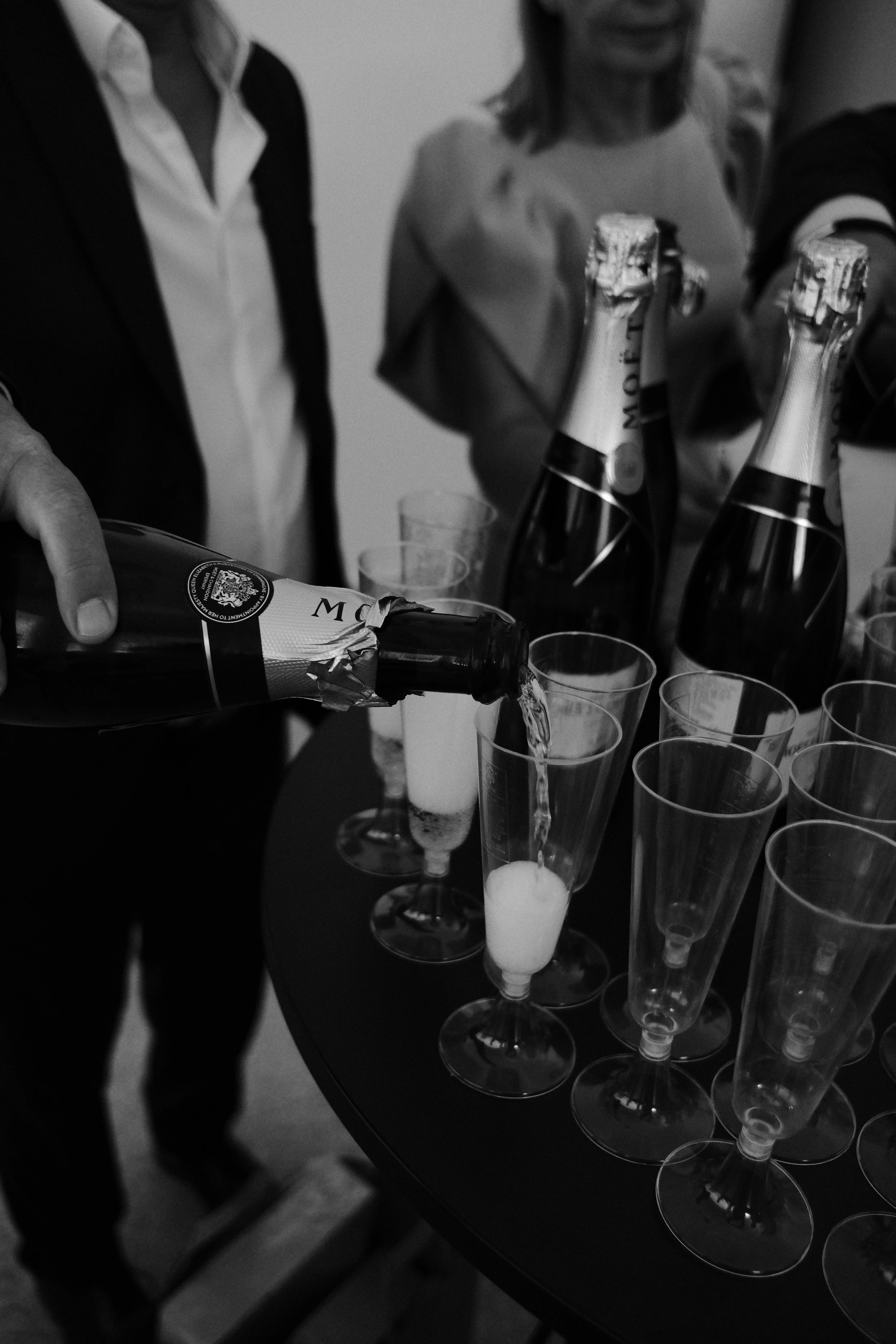 A tray of champagne bottles and glasses at the reception, black and white
