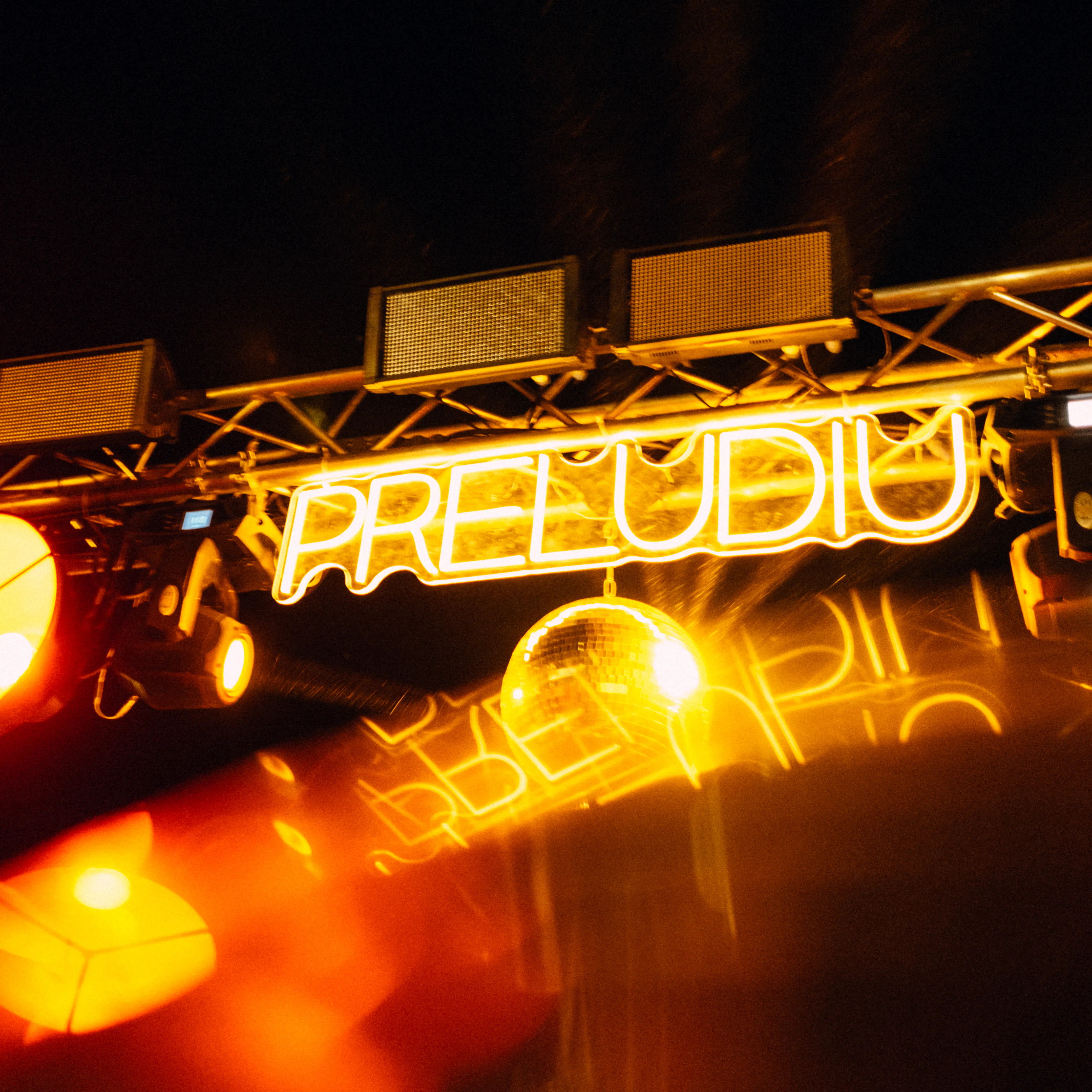 A glowing "Preludiu" sign in warm neon orange