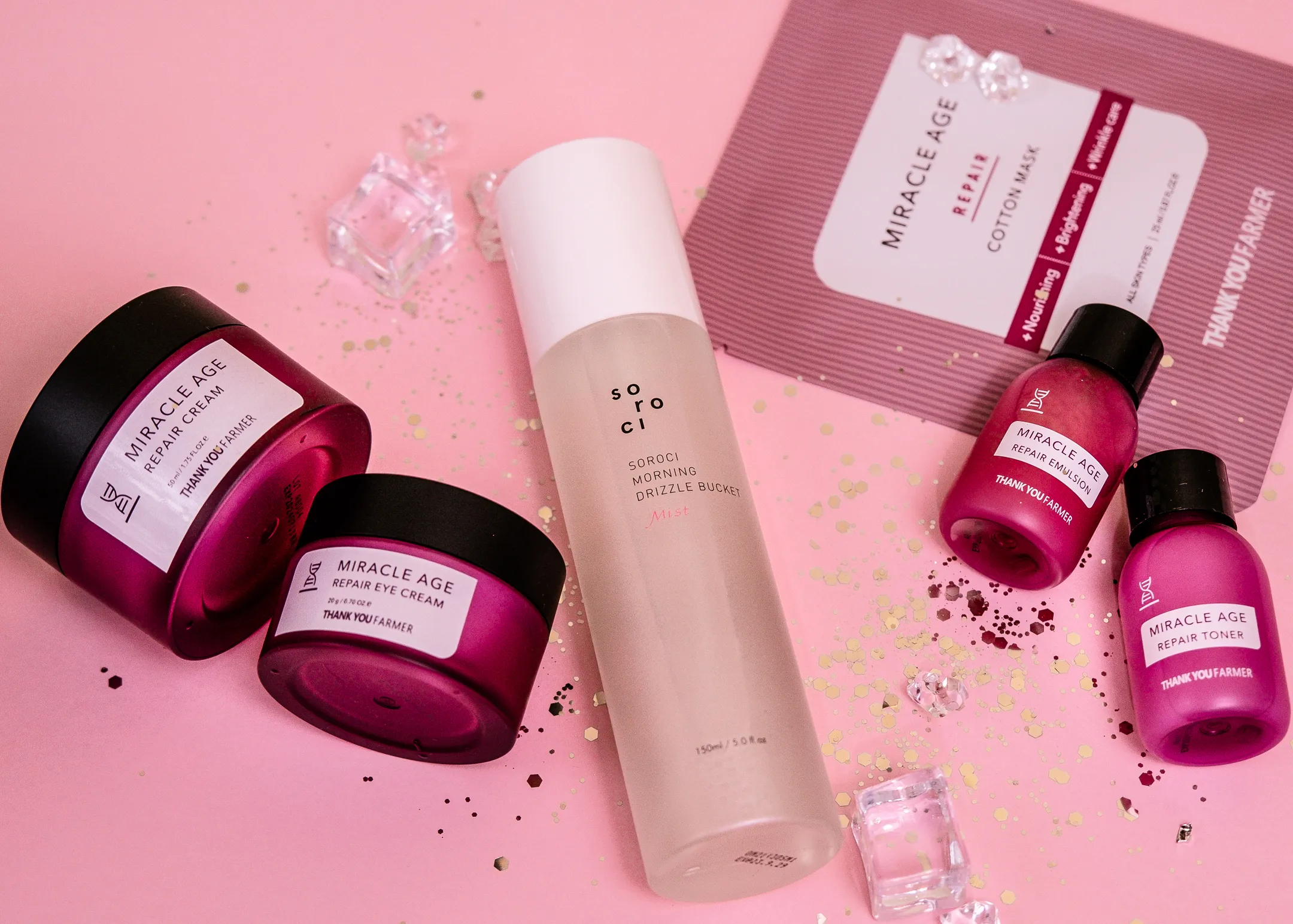A pink skincare gift set with ice cubes and gold glitter