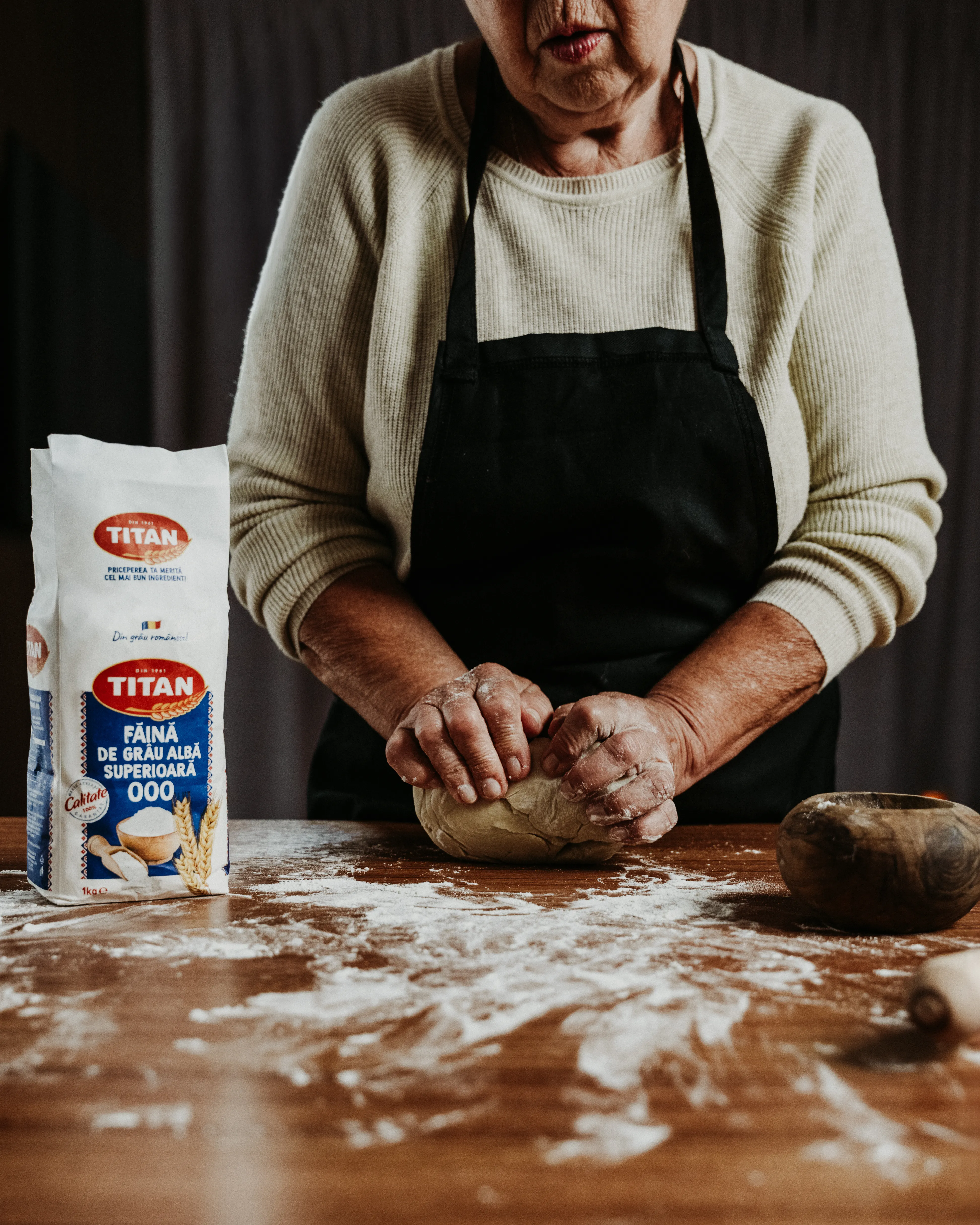 Close-up of hands kneading dough on a wooden table