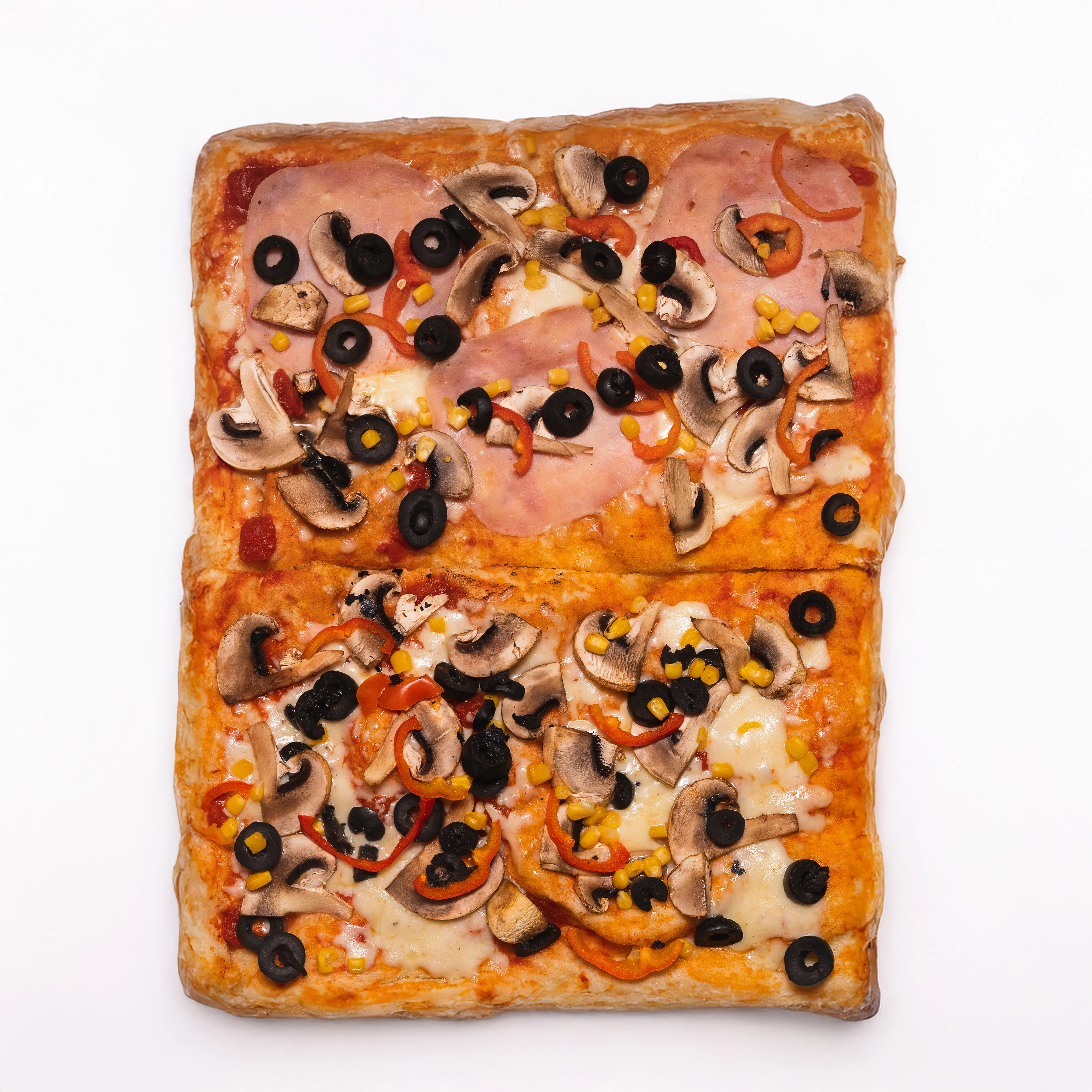 Overhead view of a square flatbread pizza topped with mushroom, olive, corn, and pepper