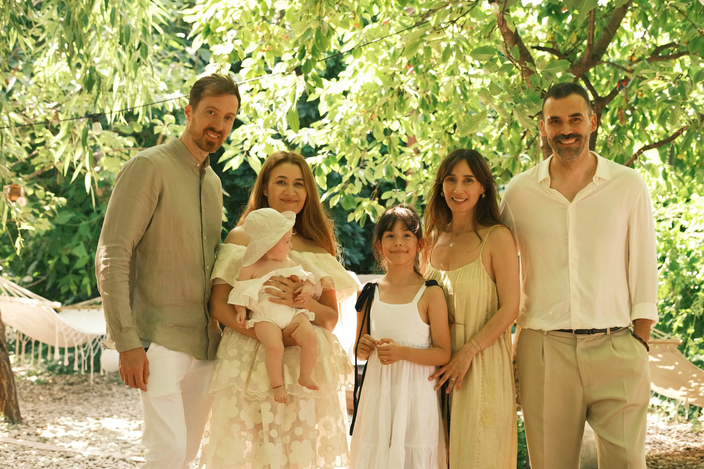 A second family group portrait under the trees, the baby in her mother's arms